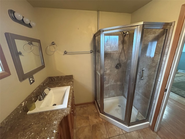 bathroom featuring hardwood / wood-style floors, vanity, and a shower with door