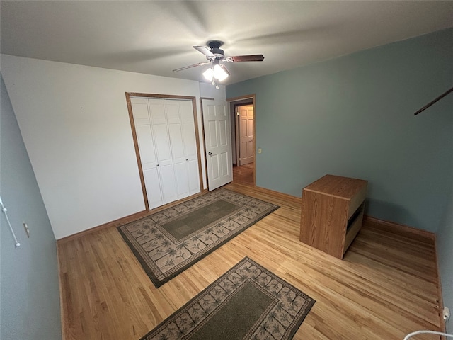 bedroom with ceiling fan, a closet, and wood-type flooring