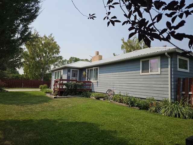 back of house featuring a lawn and a wooden deck