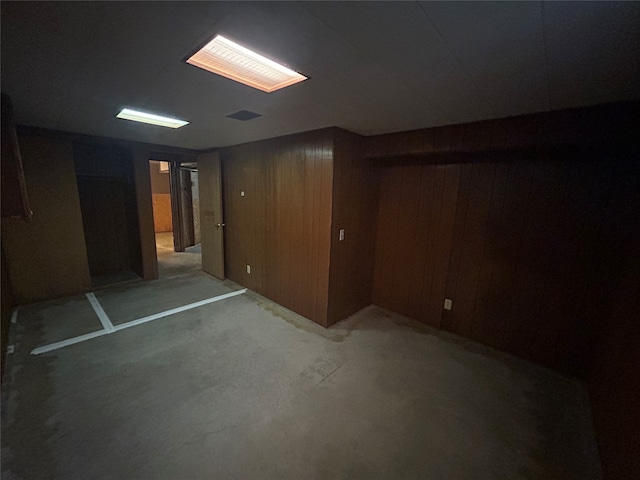 basement featuring wood walls