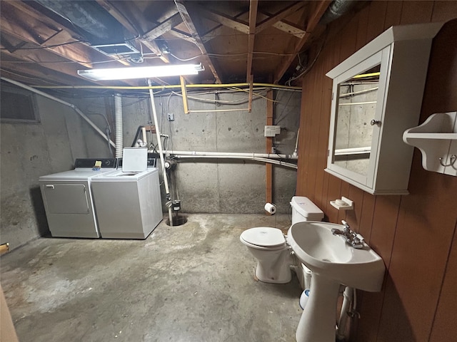 basement with wood walls and washing machine and dryer