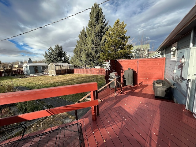 deck with grilling area, a yard, and a shed