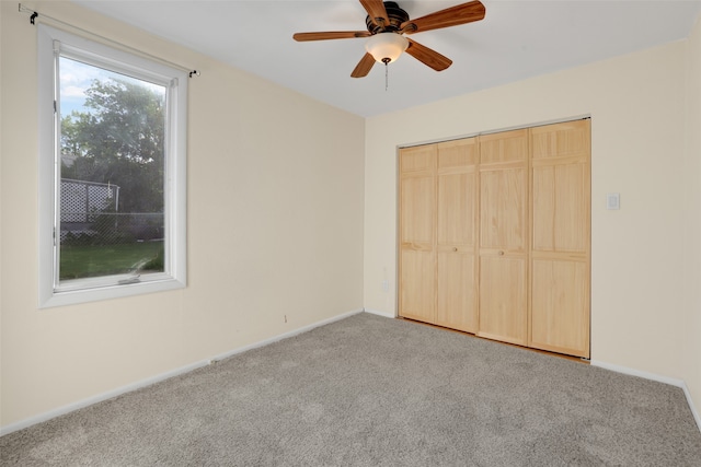 unfurnished bedroom featuring carpet flooring, ceiling fan, and a closet