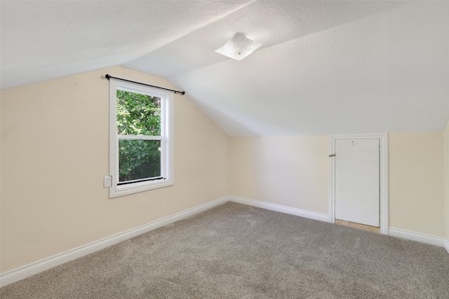 bonus room featuring lofted ceiling, a textured ceiling, and carpet flooring