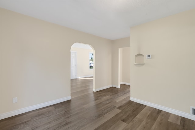 spare room with dark wood-type flooring