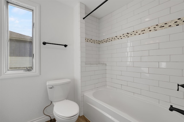 bathroom with toilet and tiled shower / bath