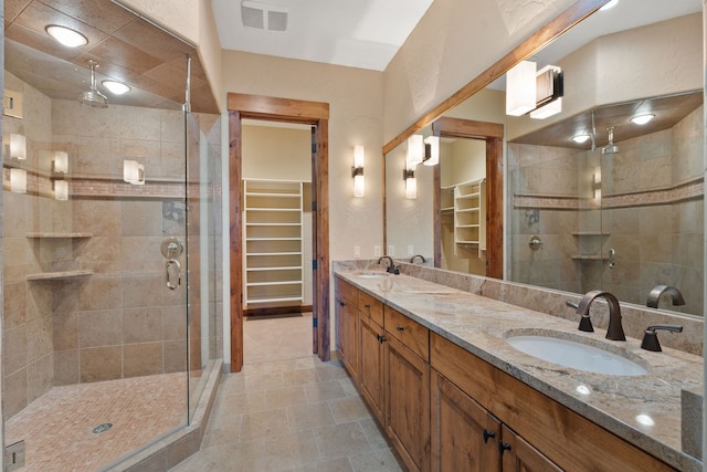 bathroom with a shower with door and vanity