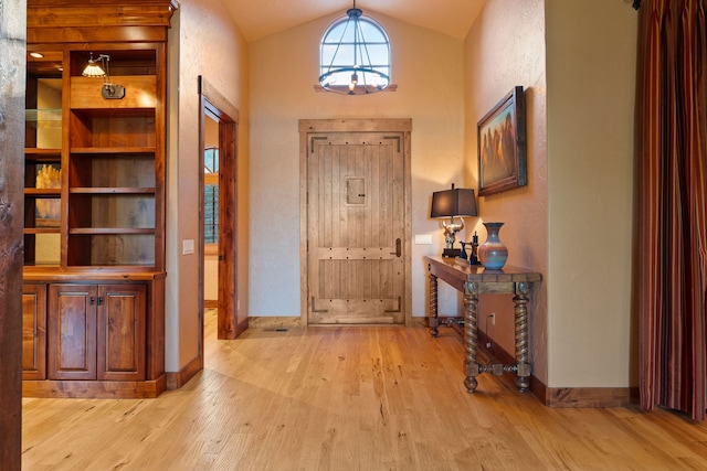 foyer featuring light wood-type flooring and lofted ceiling