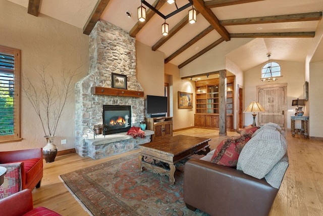 living room featuring a healthy amount of sunlight, beam ceiling, light hardwood / wood-style flooring, and a fireplace