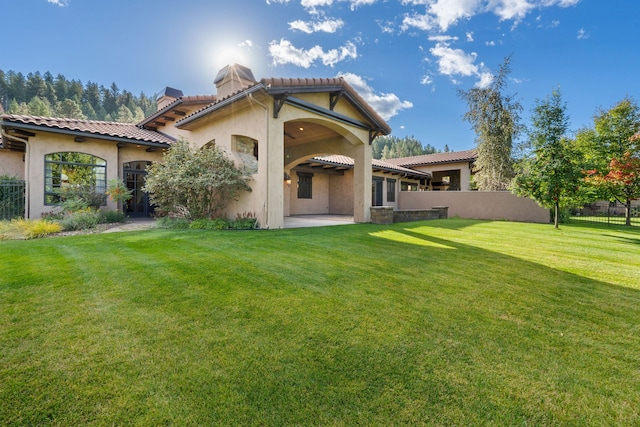 back of house with a patio and a yard