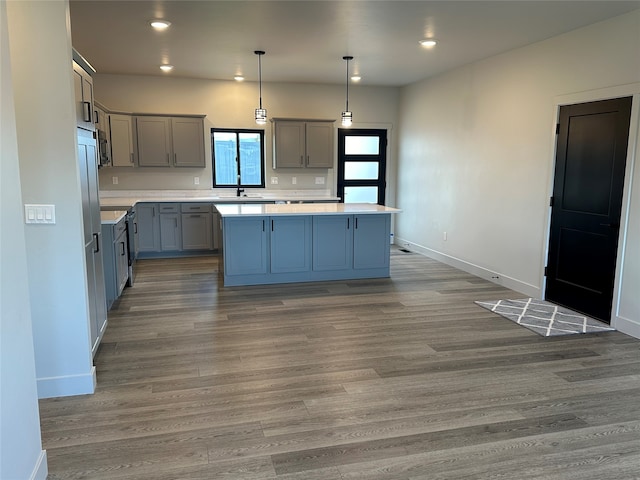 kitchen featuring gray cabinetry, pendant lighting, a center island, ceiling fan, and hardwood / wood-style flooring