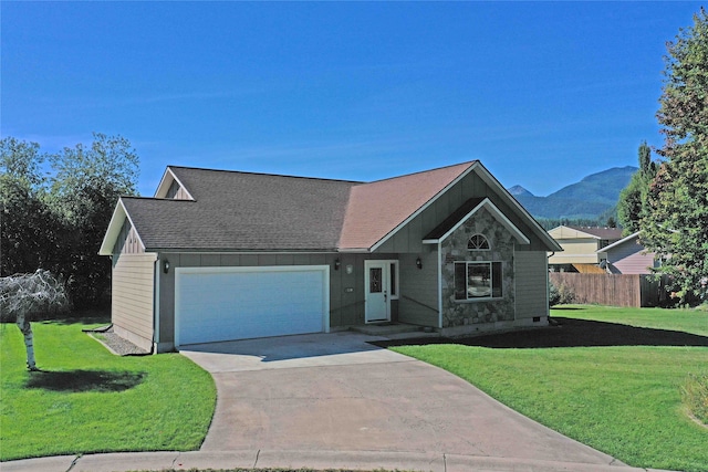 view of front of house featuring a front yard, a mountain view, and a garage