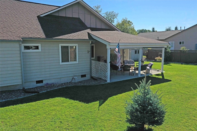 rear view of house featuring a lawn and a patio