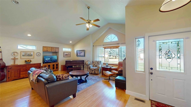 living room featuring ceiling fan, light wood-type flooring, and high vaulted ceiling