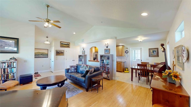 living room featuring light wood-type flooring, ceiling fan, and high vaulted ceiling