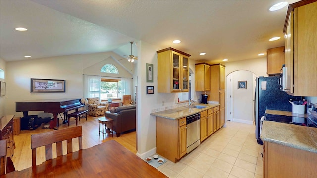 kitchen with vaulted ceiling, light tile patterned floors, ceiling fan, stainless steel dishwasher, and sink