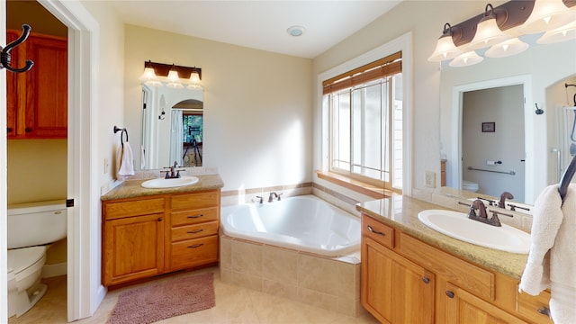 bathroom with tile patterned floors, tiled bath, vanity, and toilet