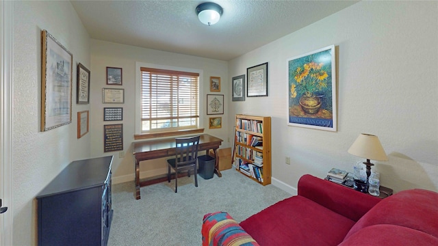 carpeted office space featuring a textured ceiling