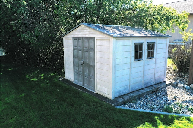 view of outbuilding featuring a lawn