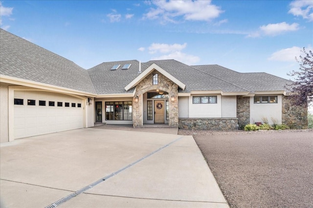 view of front of house featuring stucco siding, a shingled roof, driveway, stone siding, and an attached garage