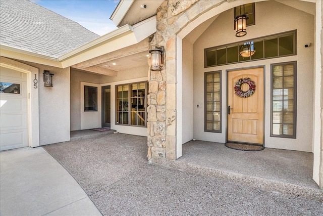 property entrance with stucco siding, a shingled roof, and stone siding