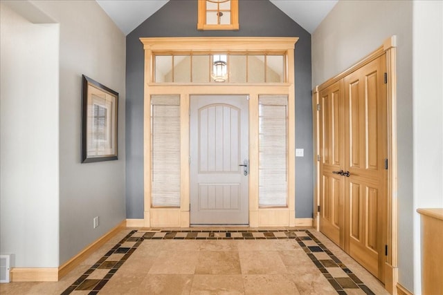 foyer entrance featuring lofted ceiling, visible vents, and baseboards