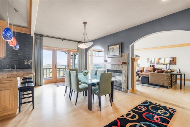 dining space featuring a tiled fireplace and light hardwood / wood-style floors