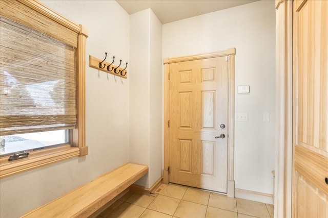 interior space featuring baseboards and light tile patterned flooring