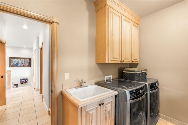 laundry room with sink, cabinets, washing machine and clothes dryer, and light tile patterned floors