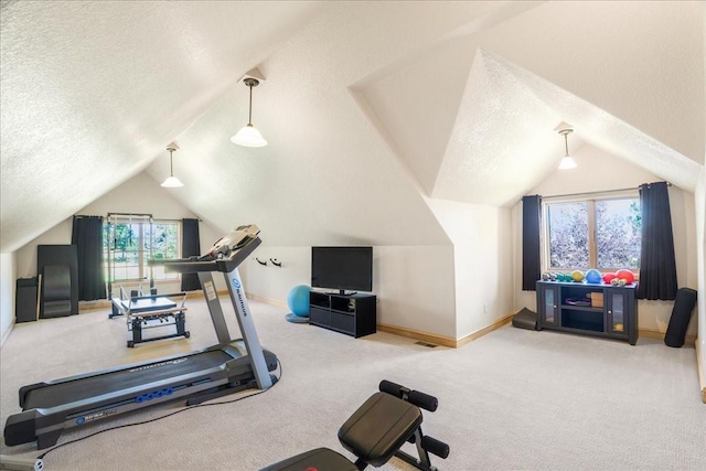 exercise area with a textured ceiling, vaulted ceiling, carpet, and baseboards