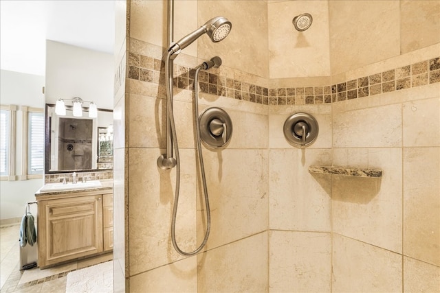 bathroom with a tile shower and vanity