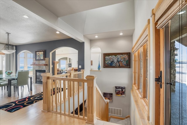 corridor featuring a textured ceiling and light hardwood / wood-style floors