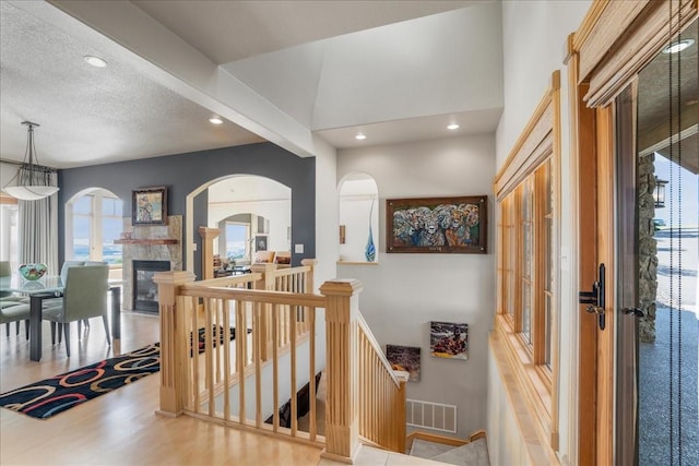 entryway featuring a glass covered fireplace, visible vents, wood finished floors, and recessed lighting
