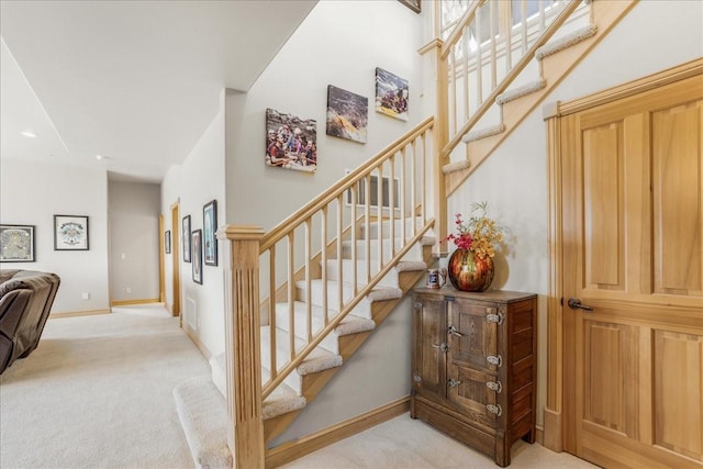 stairway featuring visible vents, baseboards, and carpet floors