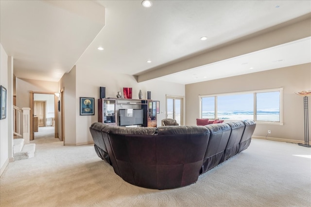 carpeted living room with beam ceiling