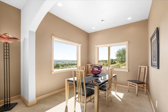 dining room featuring recessed lighting, arched walkways, light colored carpet, baseboards, and visible vents