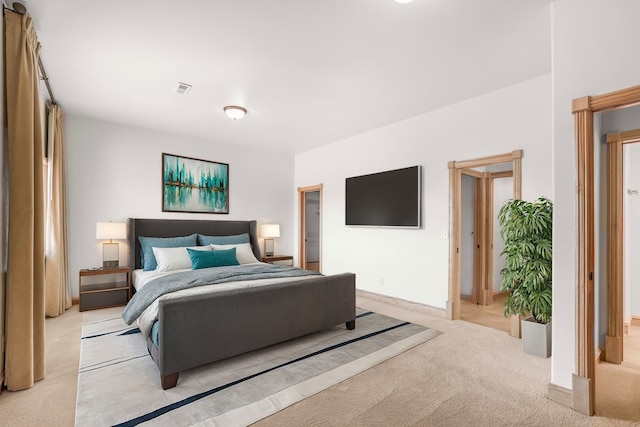 bedroom with baseboards, visible vents, and light colored carpet