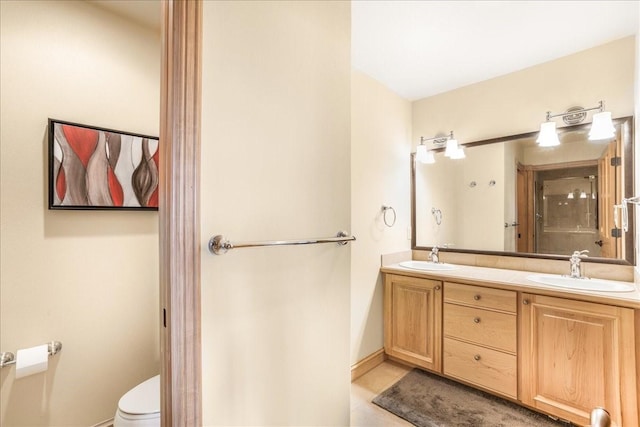 full bath with toilet, tile patterned flooring, double vanity, and a sink