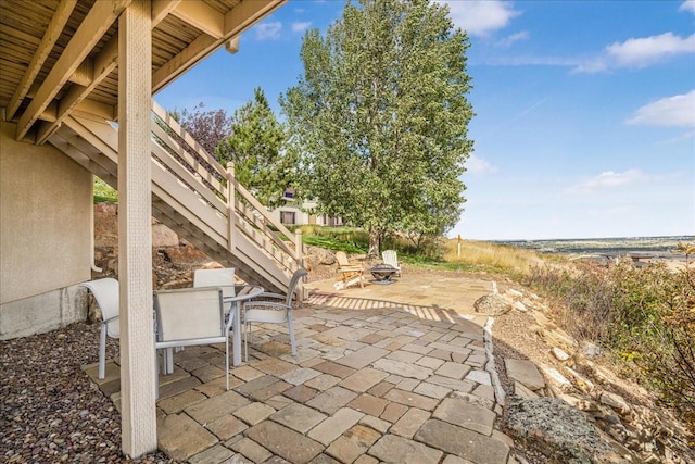 view of patio / terrace featuring a fire pit, stairs, and outdoor dining space