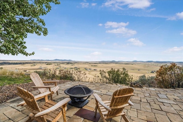 view of patio with an outdoor fire pit and a mountain view