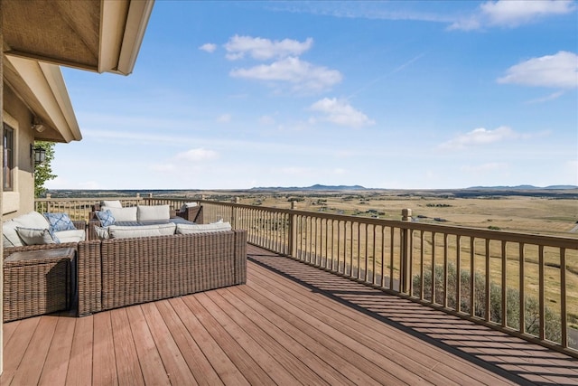 wooden terrace with an outdoor hangout area and a rural view