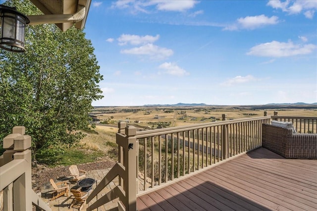wooden deck with an outdoor fire pit and a mountain view