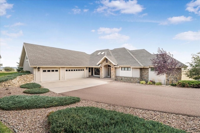 view of front of house with concrete driveway, stone siding, an attached garage, and stucco siding