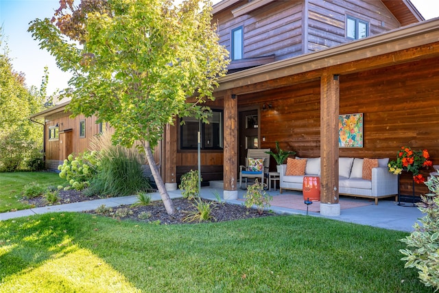 exterior space with outdoor lounge area, a front lawn, and a patio area