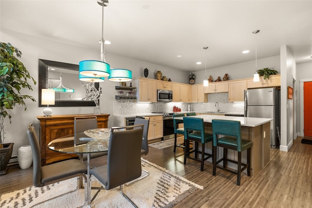 dining space with light hardwood / wood-style flooring and sink