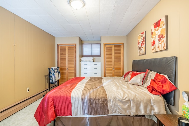 bedroom featuring multiple closets, a baseboard radiator, and carpet