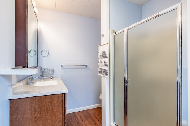 bathroom with toilet, a shower with door, hardwood / wood-style floors, and vanity