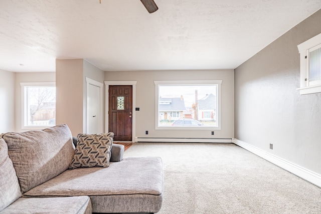 living room featuring baseboard heating, light carpet, and ceiling fan