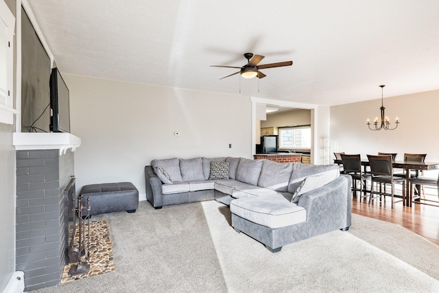 1147 W Steele St, Butte, MT 59701 - living room with carpet, a brick fireplace, and ceiling fan with notable chandelier