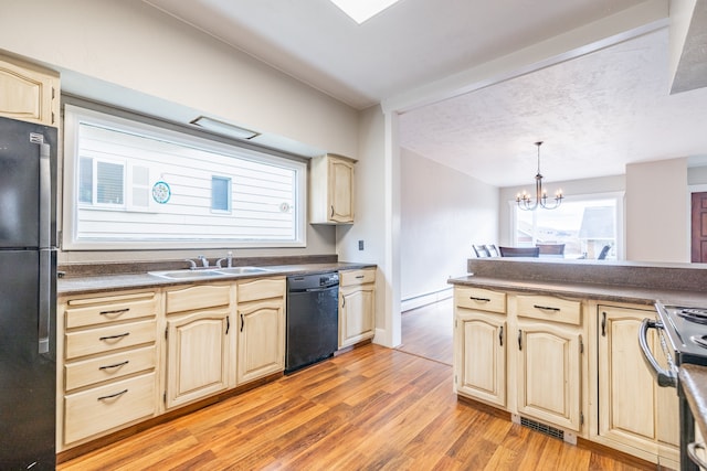 kitchen with pendant lighting, black appliances, an inviting chandelier, light hardwood / wood-style flooring, and sink